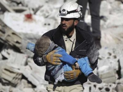 Волонтер "Белых касок" со спасенным ребенком. Фото: Reuters