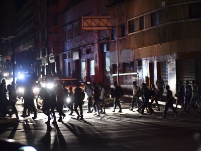 Люди переходят улицу во время отключения электроэнергии в Каракасе 7 марта. Фото: uri Cortez/AFP/Getty Images