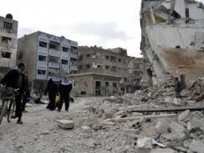 Жители проходят мимо поврежденных зданий после того, как, по словам активистов, были авиаудары сил, верных президенту Сирии Башару Асаду, в районе Дума, Дамаск, 6 февраля 2015 года. Фото: REUTERS / Amer Almohibany