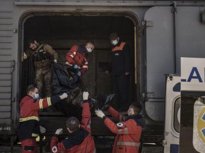 Украинский военнослужащий и сотрудники МЧС грузят в рефрижераторный вагон тело российского военного в Харькове, 5 мая 2022 год. Фото: Felipe Dana/ AP